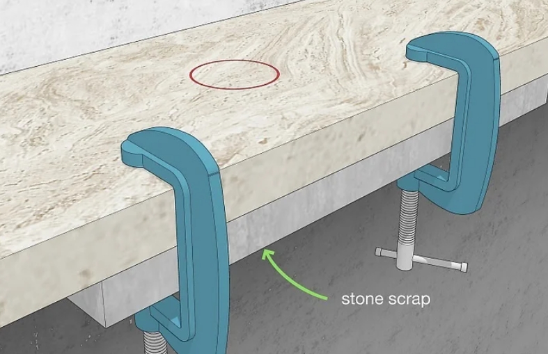 Place a piece of scrap stone directly beneath the drilling area